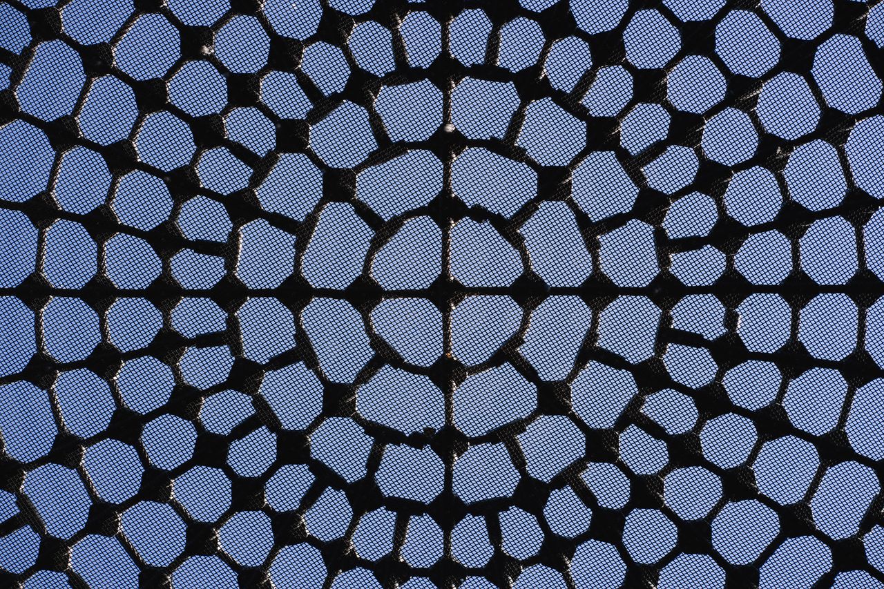 Unique geometric structure in abstract architectural roof ceiling design with sky view.