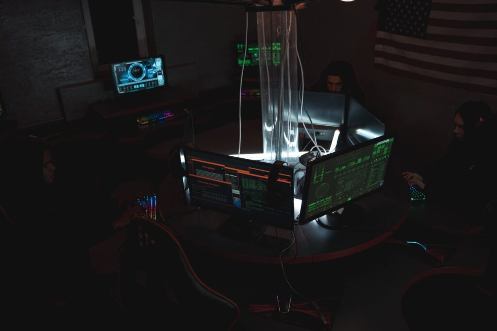 Team of post-quantum cybersecurity experts collaboratively working on data protection in a dimly lit room filled with computers.